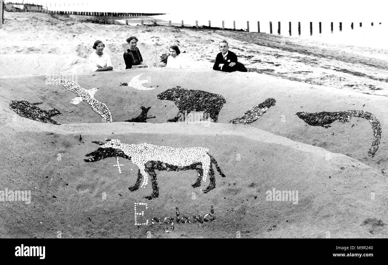 La famille sur une plage de sable fin avec sandcastle, 1930, Angleterre Banque D'Images