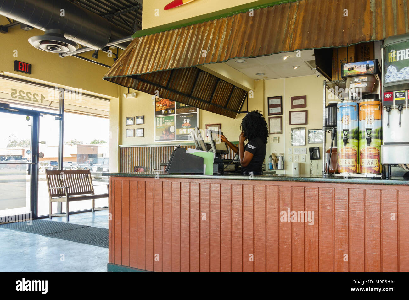 Un employé prend une commande au téléphone, l'inscrit dans un ordinateur à l'arrêt de l'aile, une aile de poulet restaurant et bar sportif. Etats Unis, Oklahoma City, Oklahoma Banque D'Images