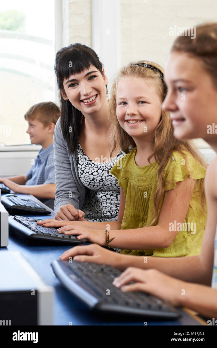 Portrait de femme élève du primaire en classe d'informatique avec l'enseignant Banque D'Images