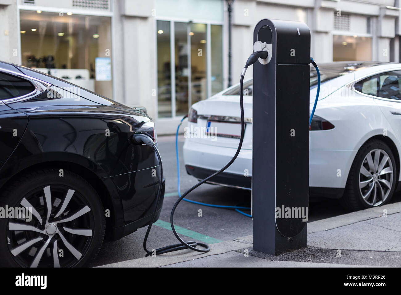 Voiture électrique moderne de charge sur la rue comme avenir de l'industrie automobile. Banque D'Images