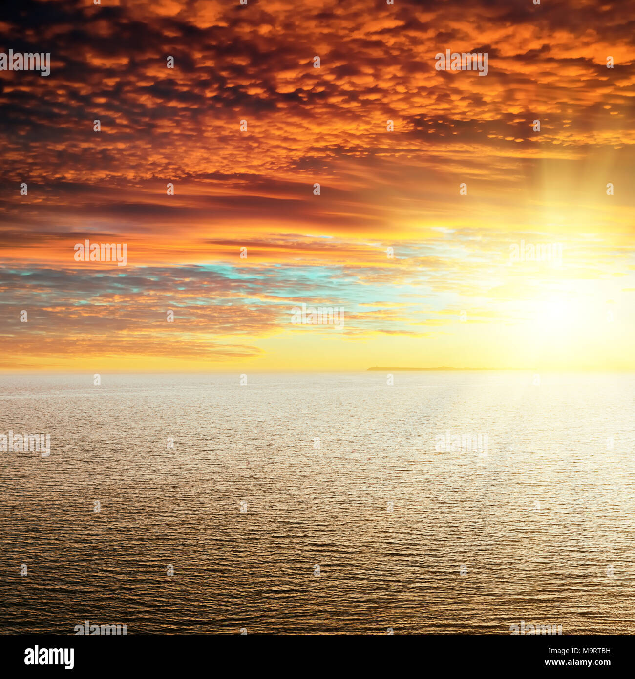 Coucher de soleil rouge dans les nuages au-dessus de la mer Banque D'Images