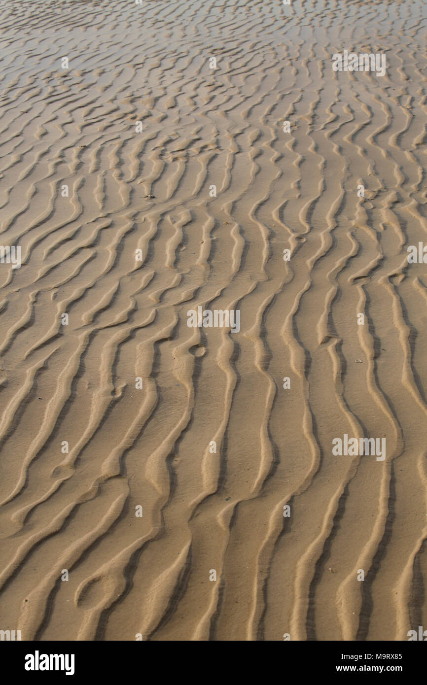 Les ondes à gauche de sable à marée basse, Dorset UK Banque D'Images