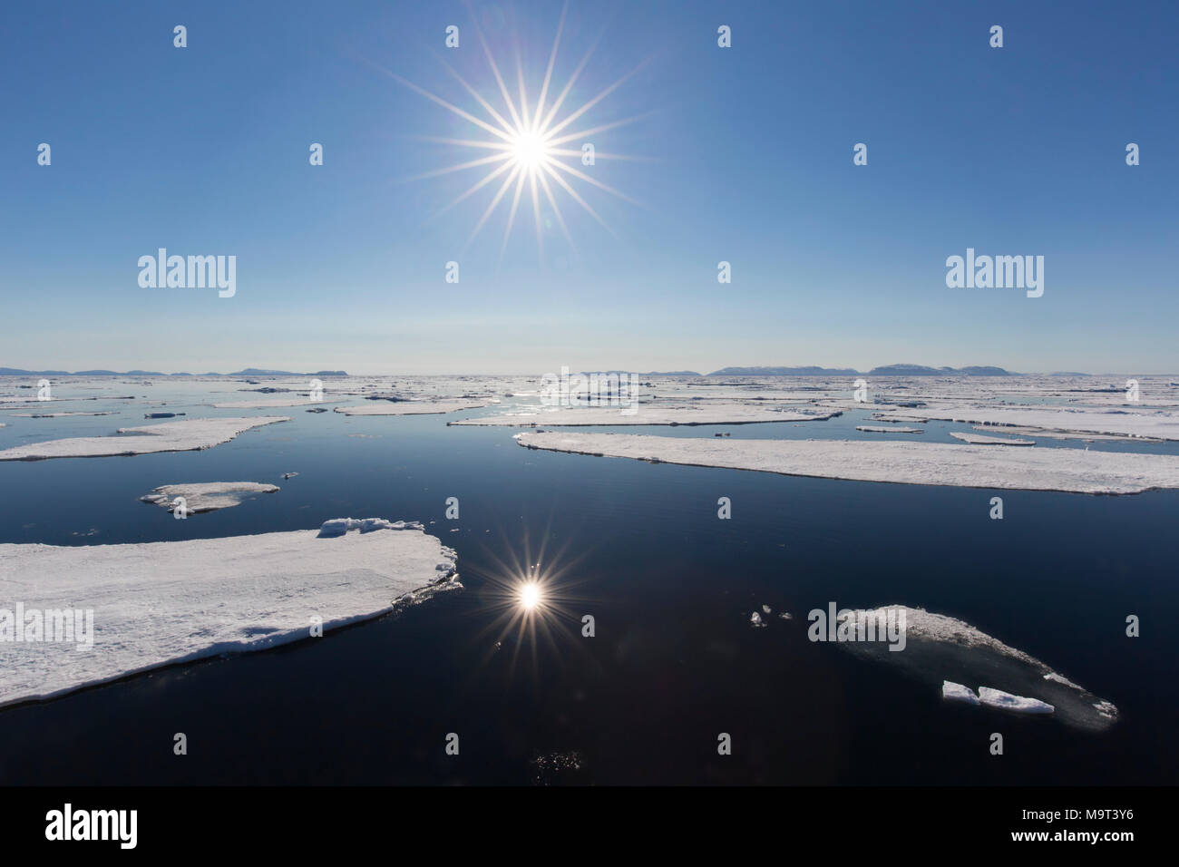 Soleil de minuit au-dessus de l'océan Arctique avec des blocs de glace à la dérive, au nord du Cercle arctique à Nordaustlandet Svalbard, Norvège, Spitzberg / Banque D'Images