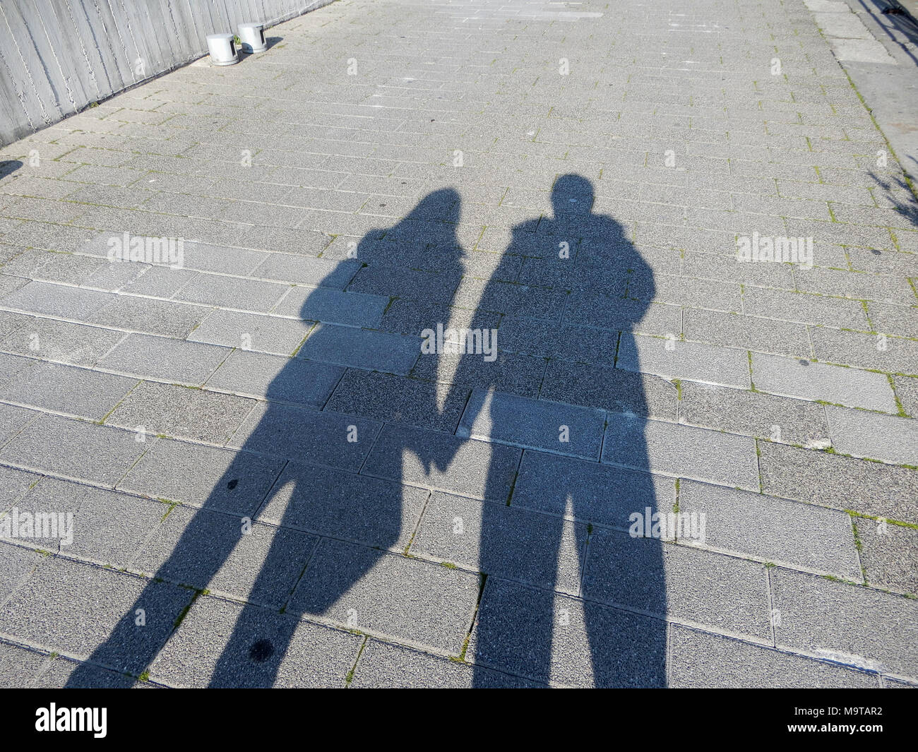 Ombre d'un couple, l'homme et la femme se tenant la main dans la rue. Banque D'Images