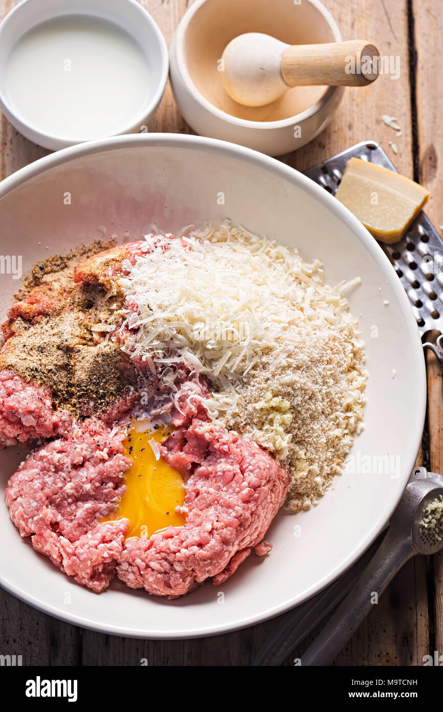 Des boulettes de viande ingrédients dans le bol. La viande de porc hachée,  assaisonnement, chapelure, oeuf, fromage parmesan Photo Stock - Alamy