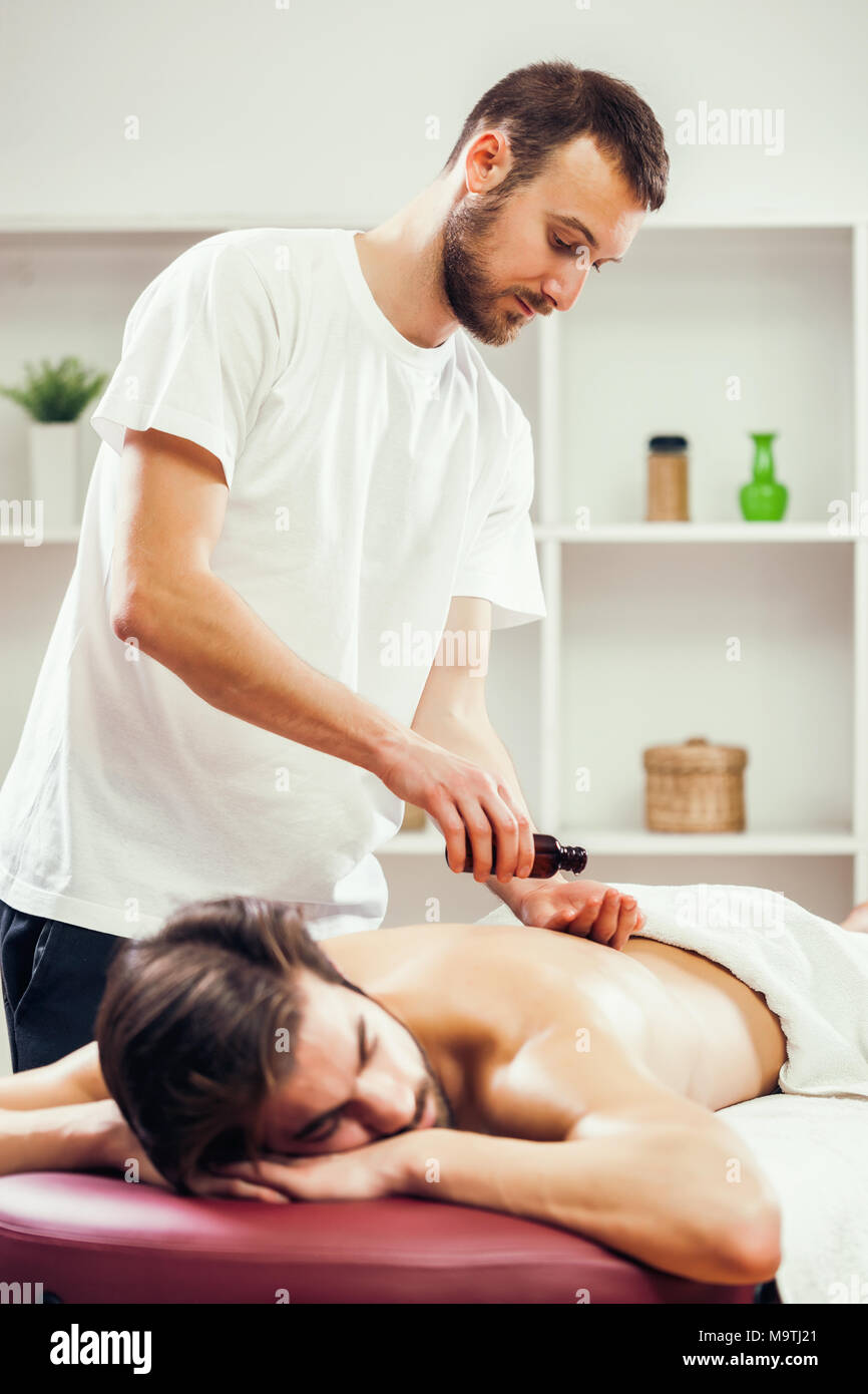 Jeune homme jouit de massage sur un soin spa. Banque D'Images