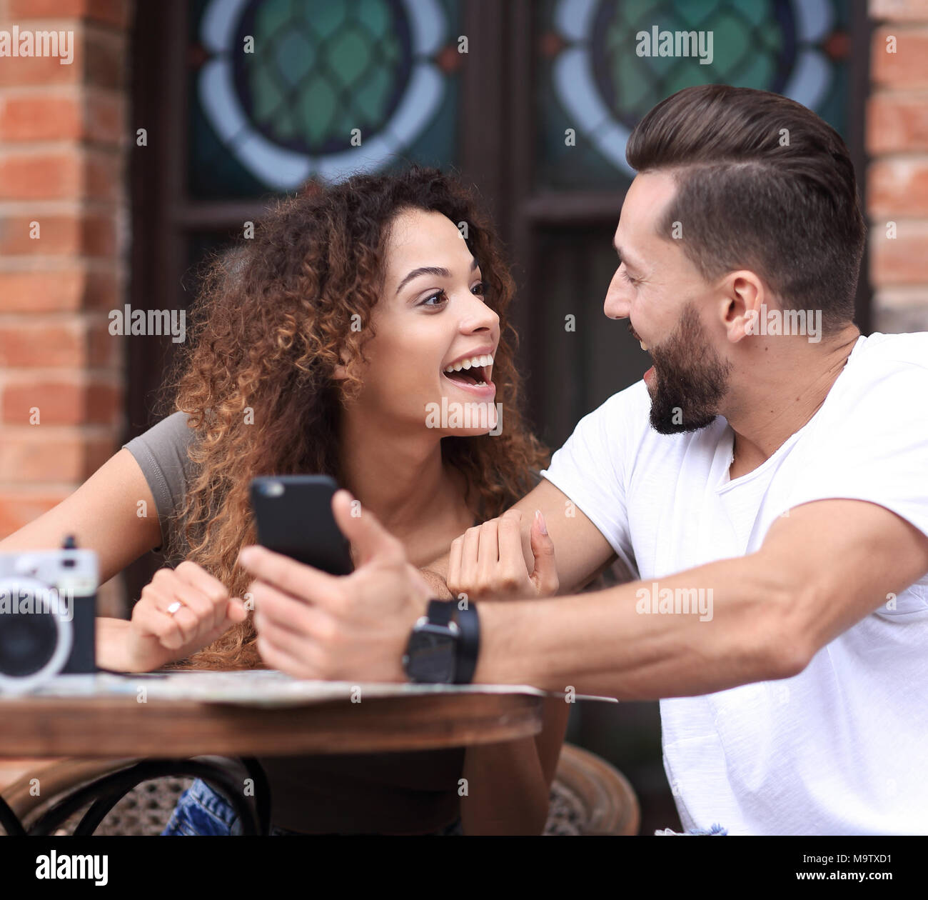 Portrait d'un jeune couple s'asseoir à une terrasse de café Banque D'Images