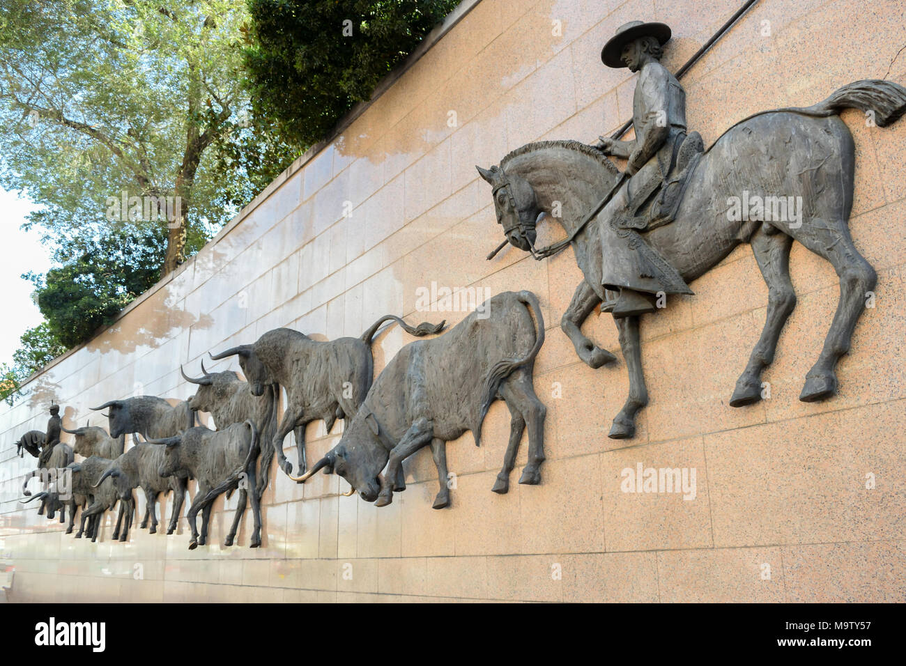 Relief en bronze de taureaux en roulant par des cavaliers à cheval vers l'arène de Las Ventas, Madrid, Espagne Banque D'Images