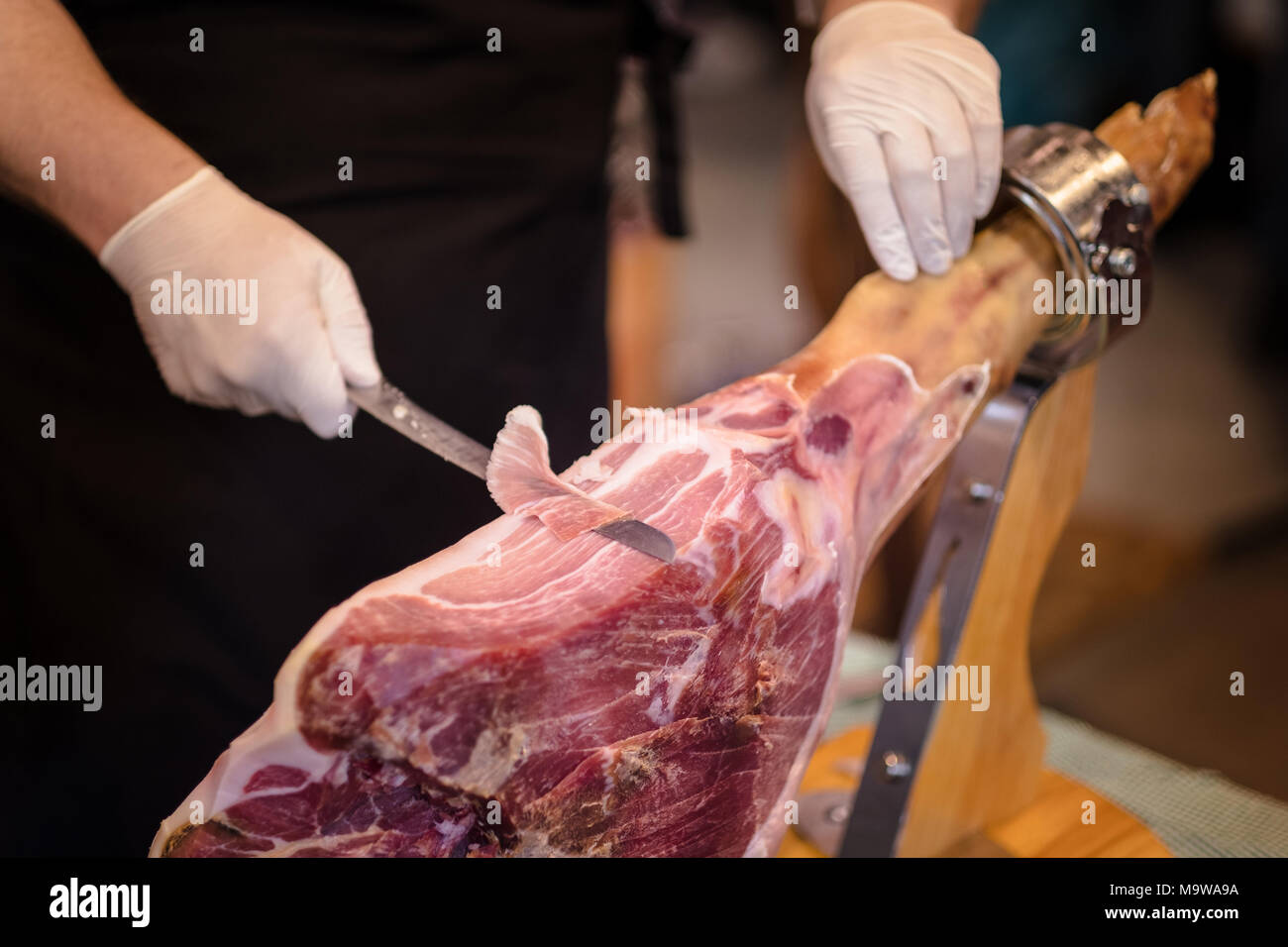 Une patte avant du jambon Serrano, également connu sous le nom de l'espagnol ou jambon ibérique Pata Negra monté sur un support en bois avec une boucherie fine tranches de c Banque D'Images