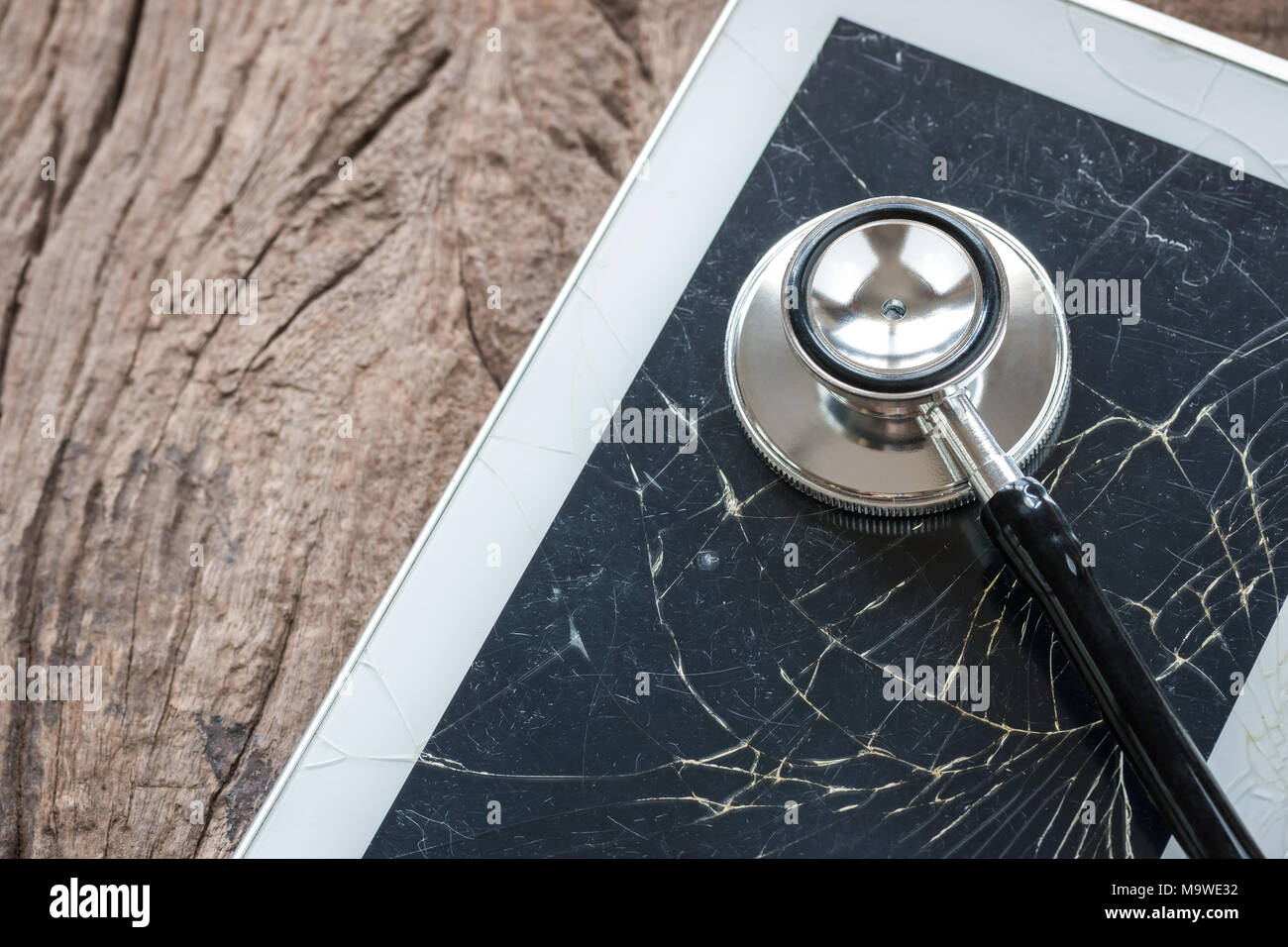 Une photo de stéthoscope sur tablette cassée, écran jusqu'à proximité des fissures sur l'écran du téléphone, Health check up concept Banque D'Images