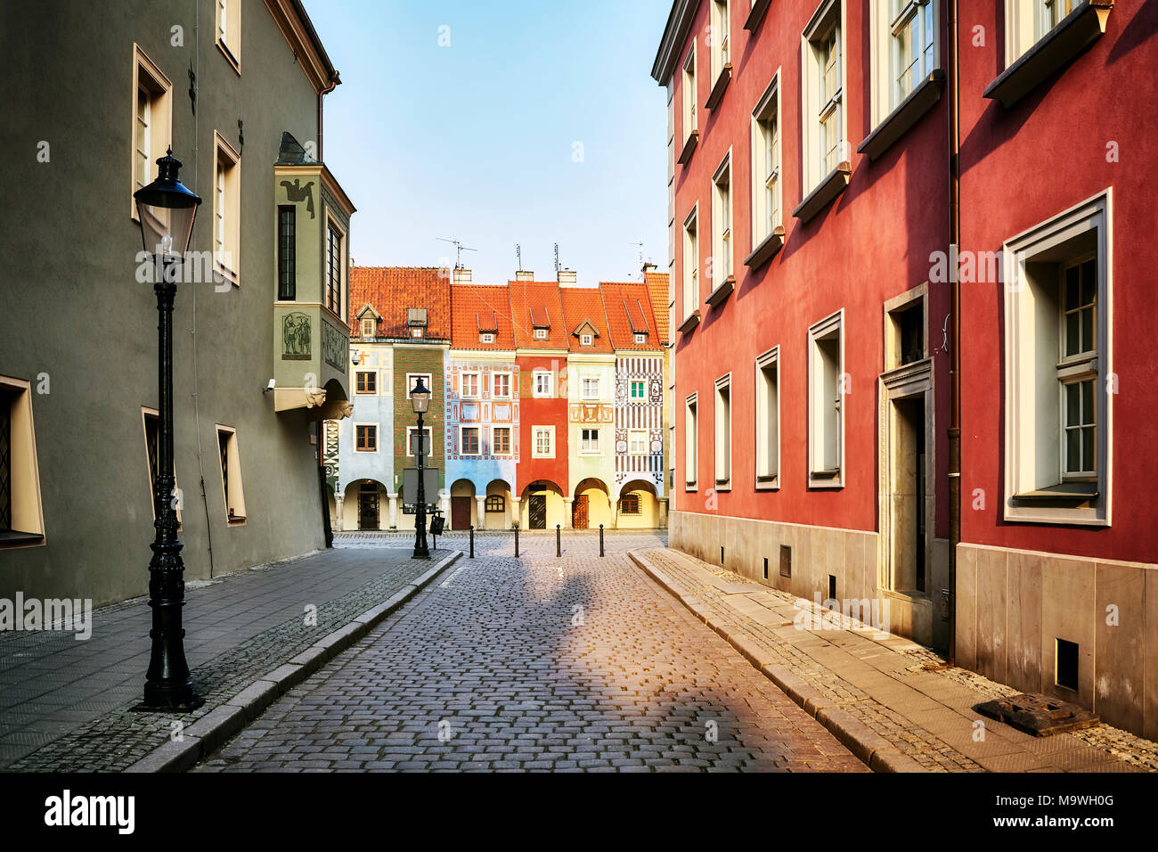 Street au marchand maisons de la Place du vieux marché de Poznan, en Pologne, au lever du soleil. Banque D'Images