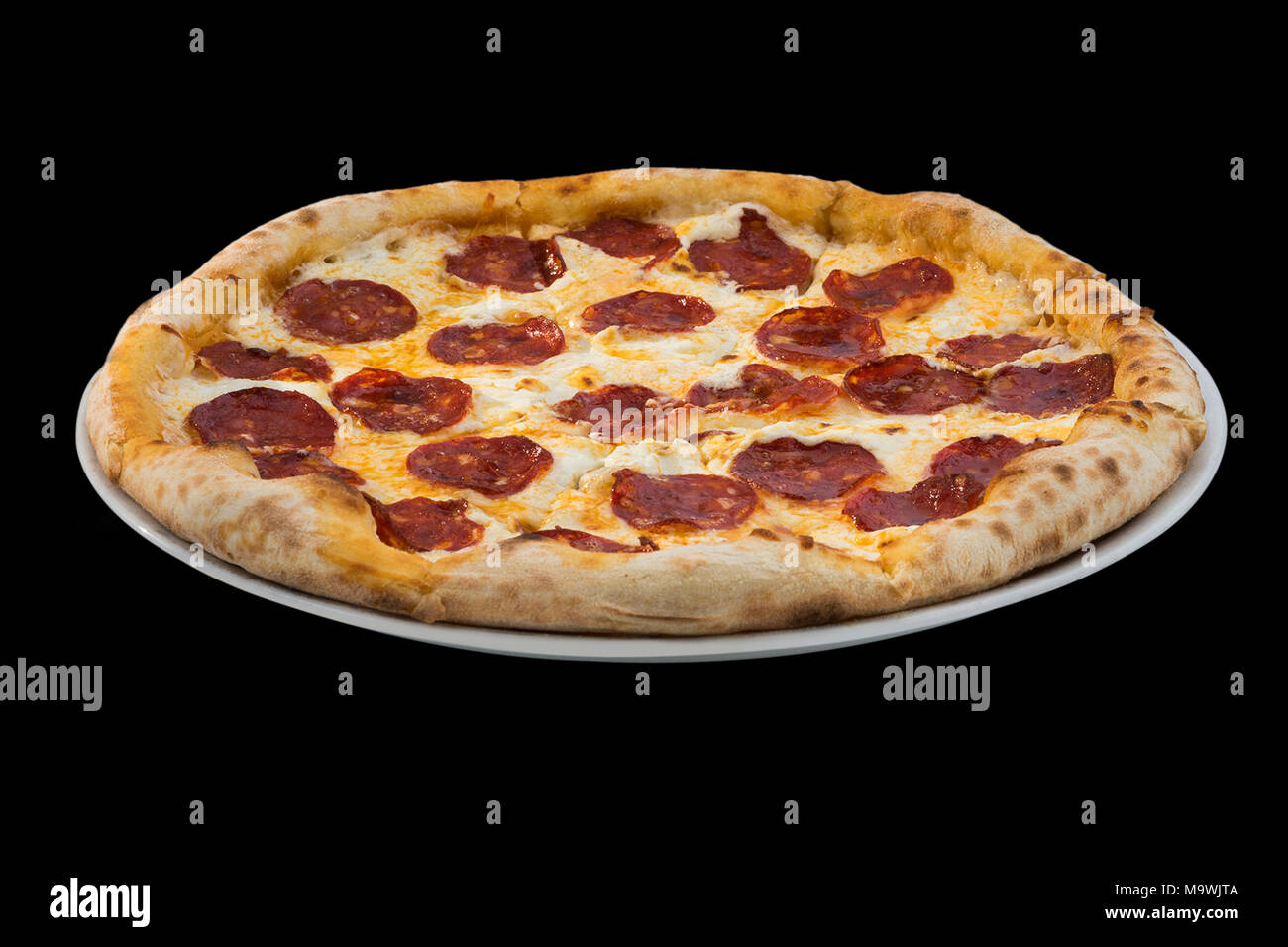 Pizza au salami et fromage sur fond noir Banque D'Images