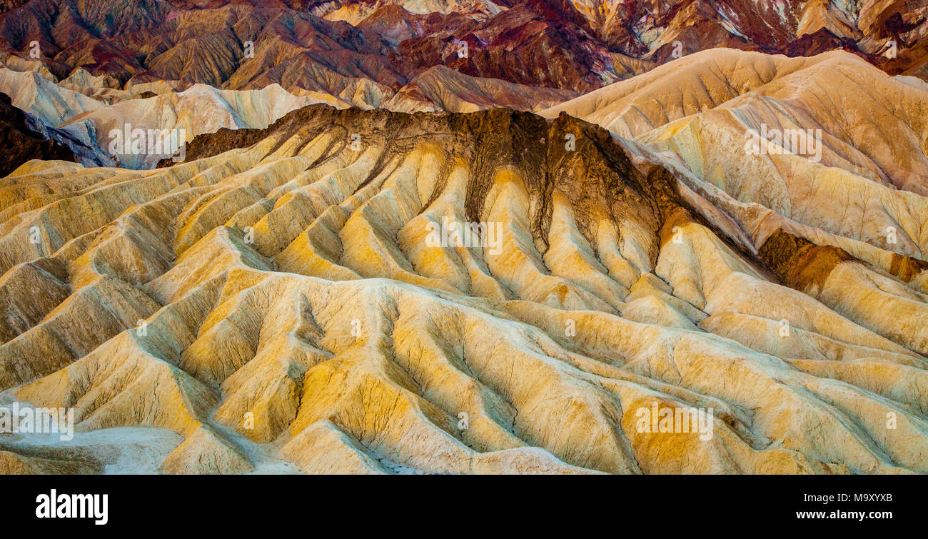 Les formations géologiques colorées de Zabriskie Point au lever du soleil dans la Death Valley National Park, California Banque D'Images