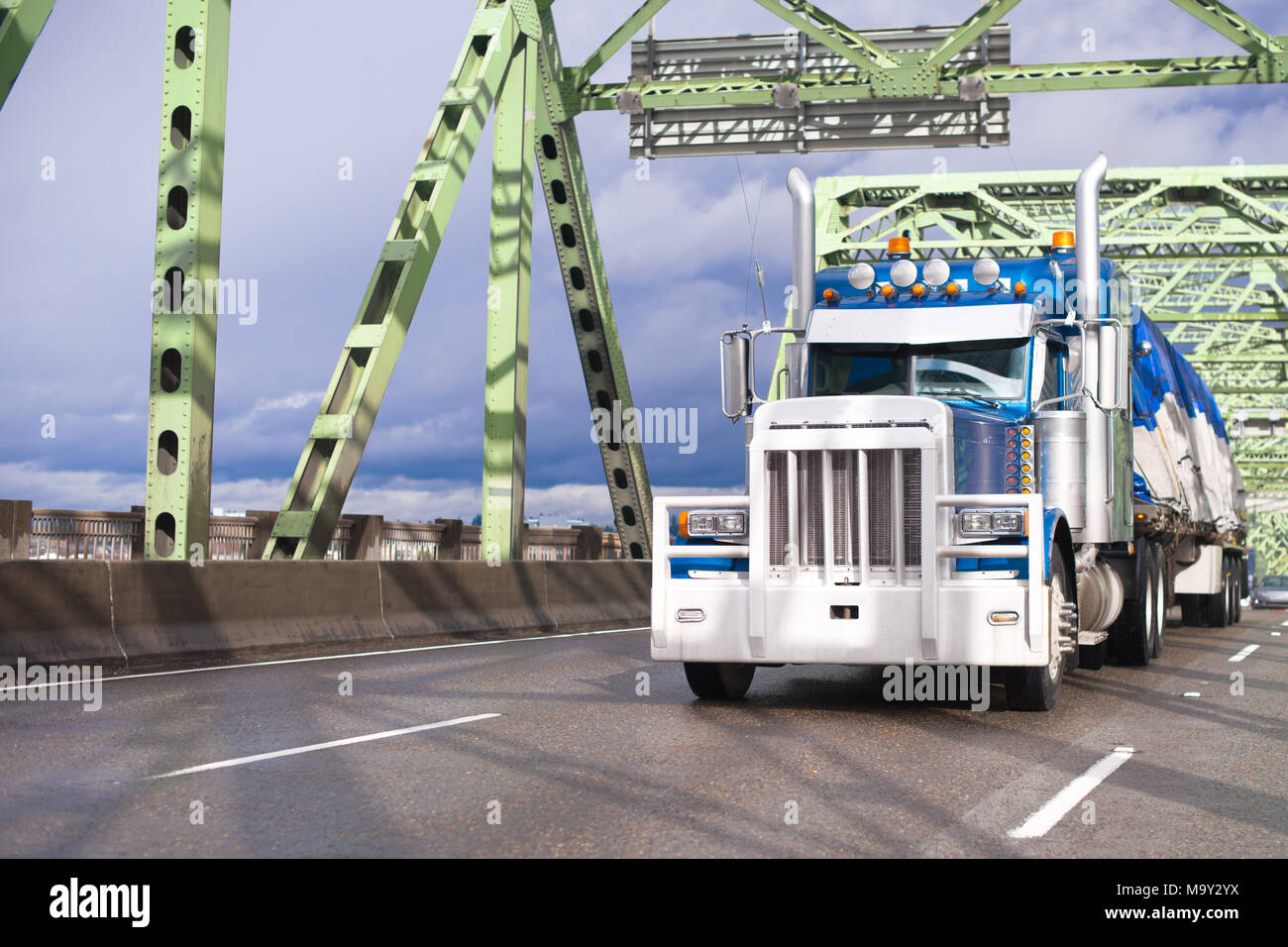 Grand classique bleu gros camion semi truck avec protection de grille  pare-choc et couverts chargement sur remorque à plateau en bois pont à  travers la rivière Columbia Photo Stock - Alamy