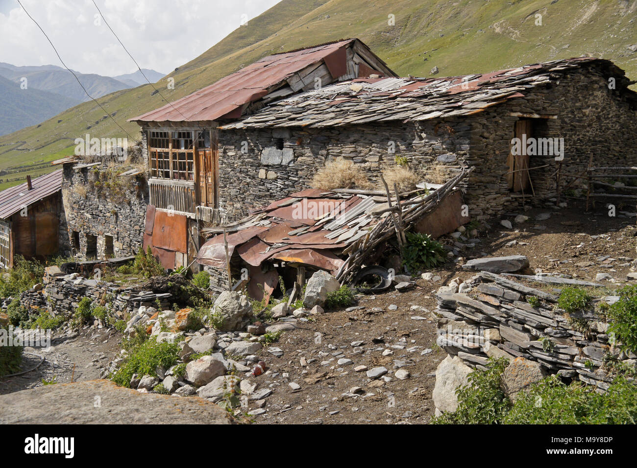 Vieilles maisons et une grange en pierre avec toiture en ardoise dans le village d'Ushguli, Upper Svaneti, Géorgie Banque D'Images