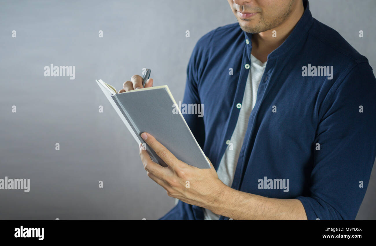 L'homme écrit sur ordinateur portable sur fond gris Banque D'Images