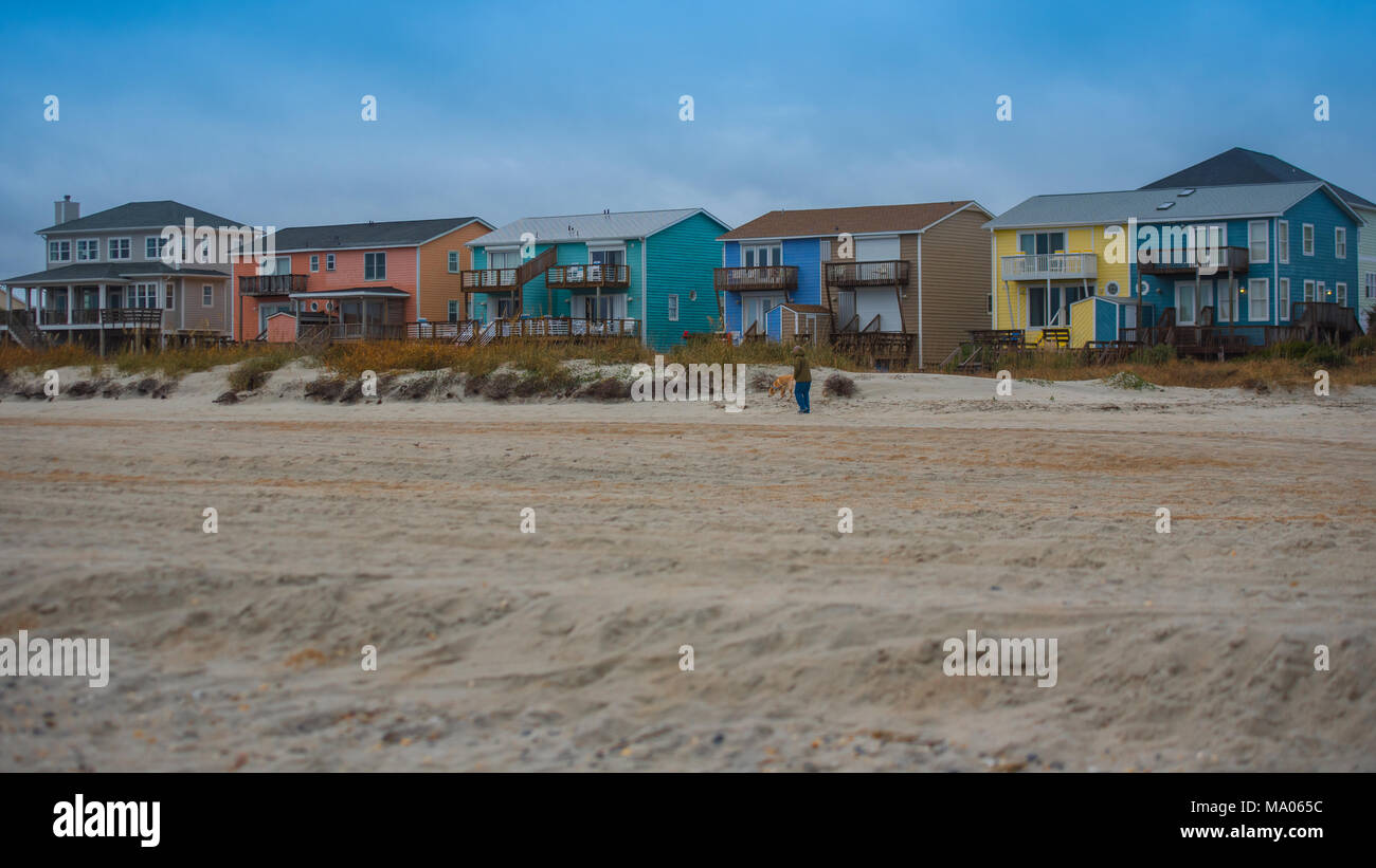 Maisons de Plage tirés de la mer sur l'île d'Émeraude en Caroline du Nord avec du sable et de l'herbe au premier plan sur jour de tempête. Banque D'Images