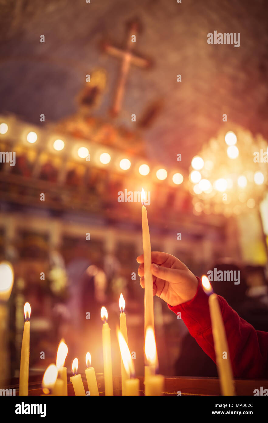 Enfant met une bougie dans l'église, prier avec foi, traditionnelle visite  d'un lieu saint pour Pâques, la grande fête chrétienne, la croyance en Dieu  concept Photo Stock - Alamy