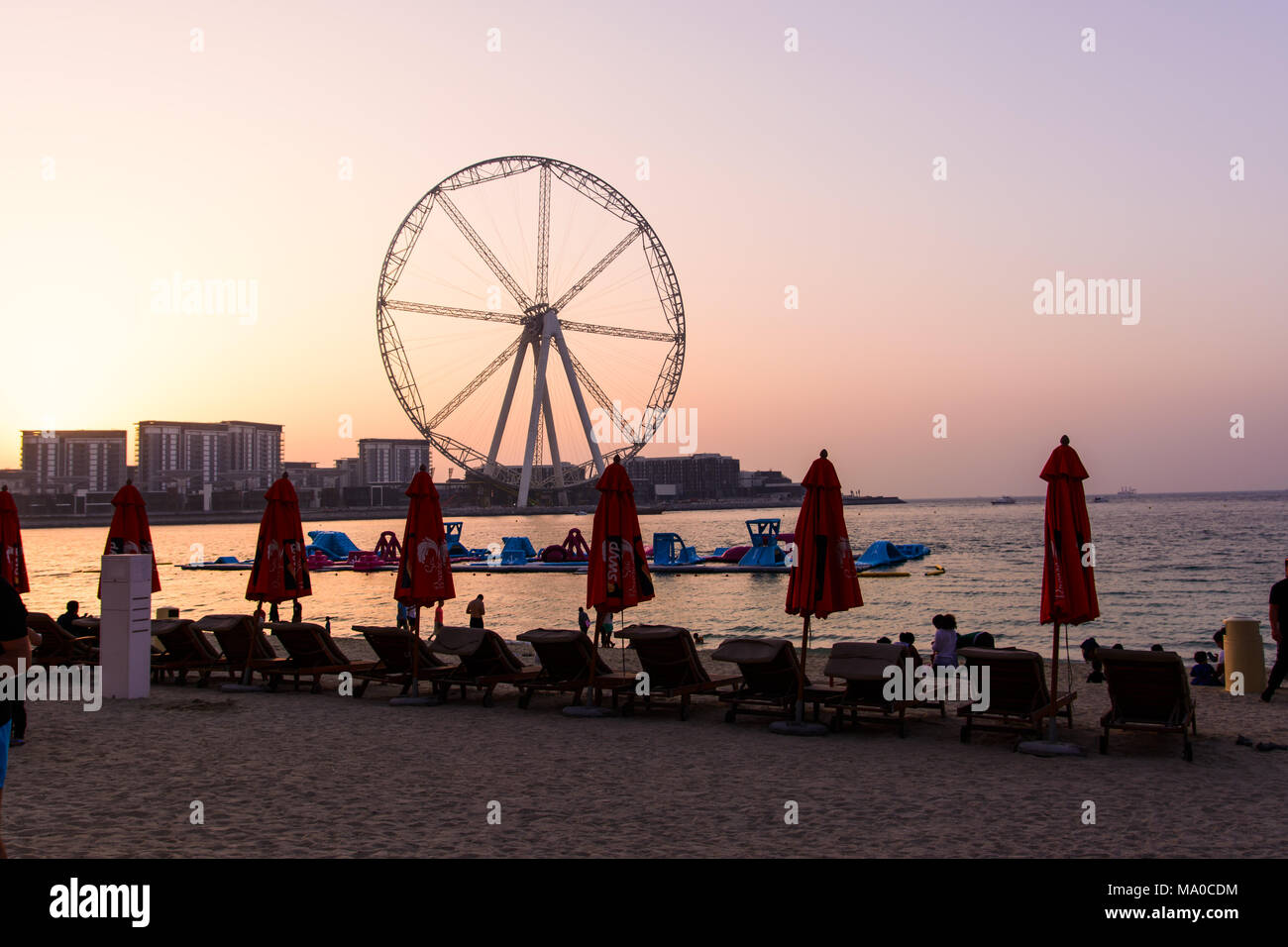 Dubaï, Émirats Arabes Unis - 8 mars, 2018 : chaises longues et romantique coucher du soleil à JBR, Jumeira Beach Resort Beach avec Ain Dubai grande roue dans le background Banque D'Images