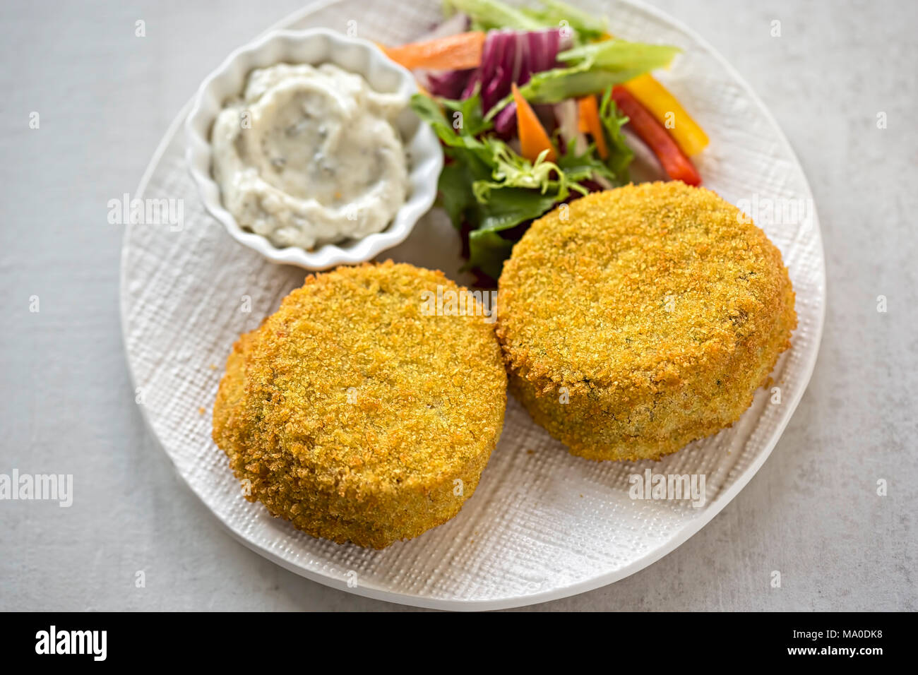 Le corégone fumé fishcakes avec la sauce tartare et salade Banque D'Images