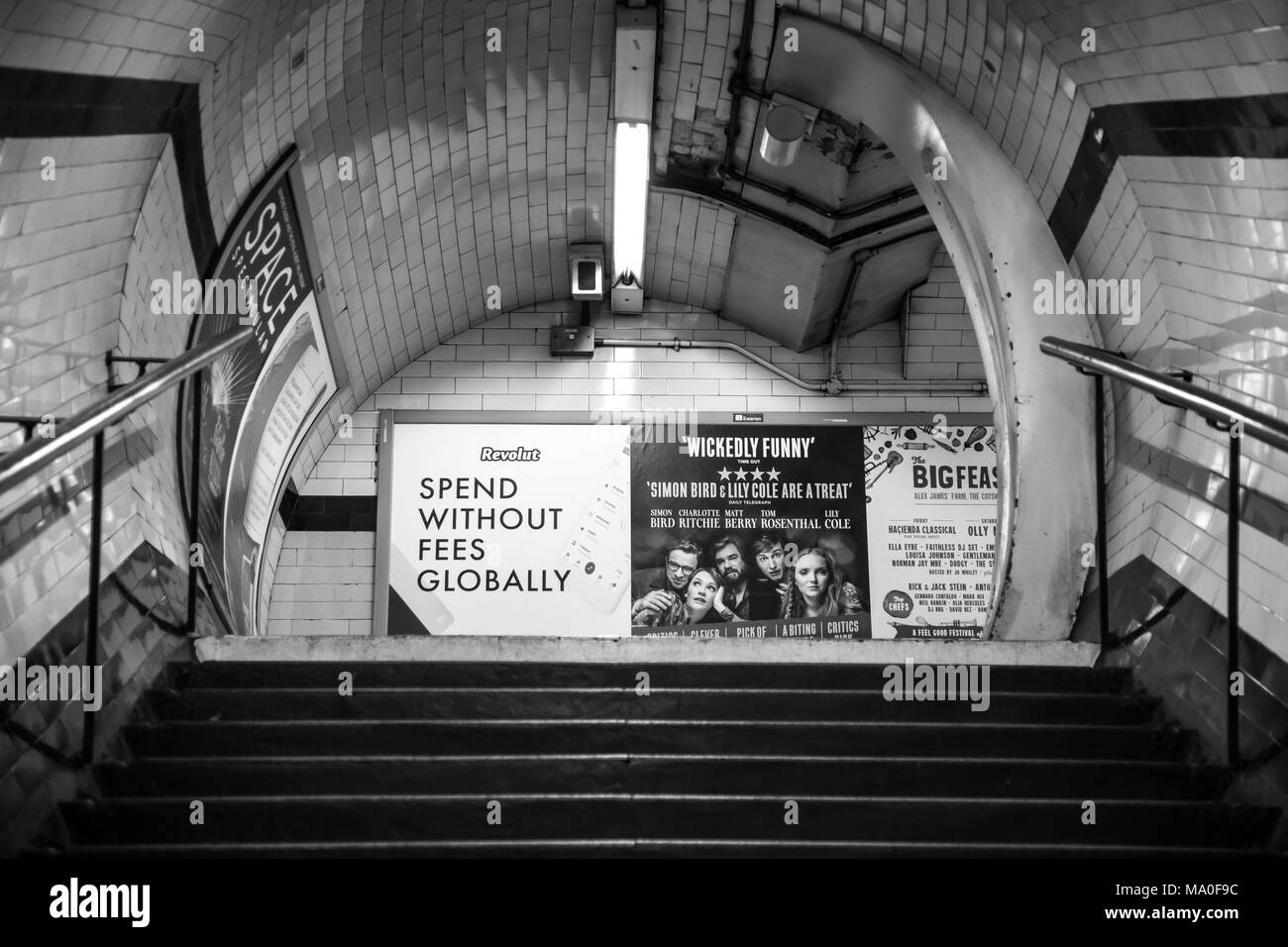 Arty noir et blanc tourné de déserté passage intérieur à la station de métro Marylebone de Londres, à la recherche des escaliers à vide de la publicité du tube d'affiches. Banque D'Images