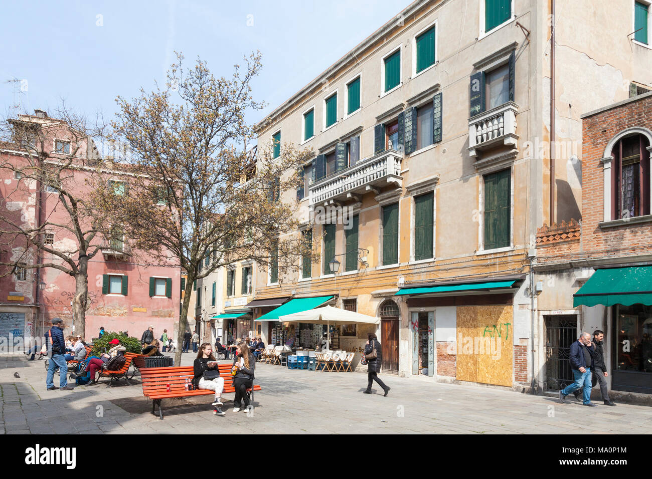 Campo Santa Maria Nova, Cannaregio, Venise, Vénétie, Italie avec les Vénitiens et les touristes assis sur des bancs profitant du soleil d'hiver Banque D'Images