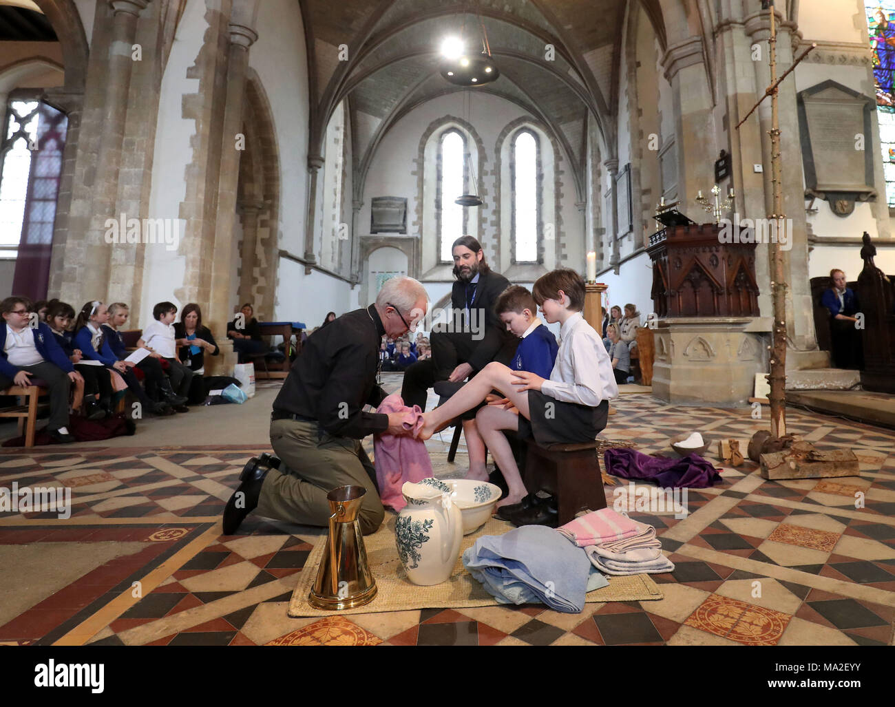 L'archevêque de Canterbury, Justin Welby lave les pieds des élèves de l'École de la cathédrale au cours de l'école service Pâques Jeudi Saint dans l'église Sainte Marie la Vierge, Minster, tandis que sur les visites d'églises, des pubs et des écoles de la mission de la semaine 'Ile', dans le Kent. Banque D'Images