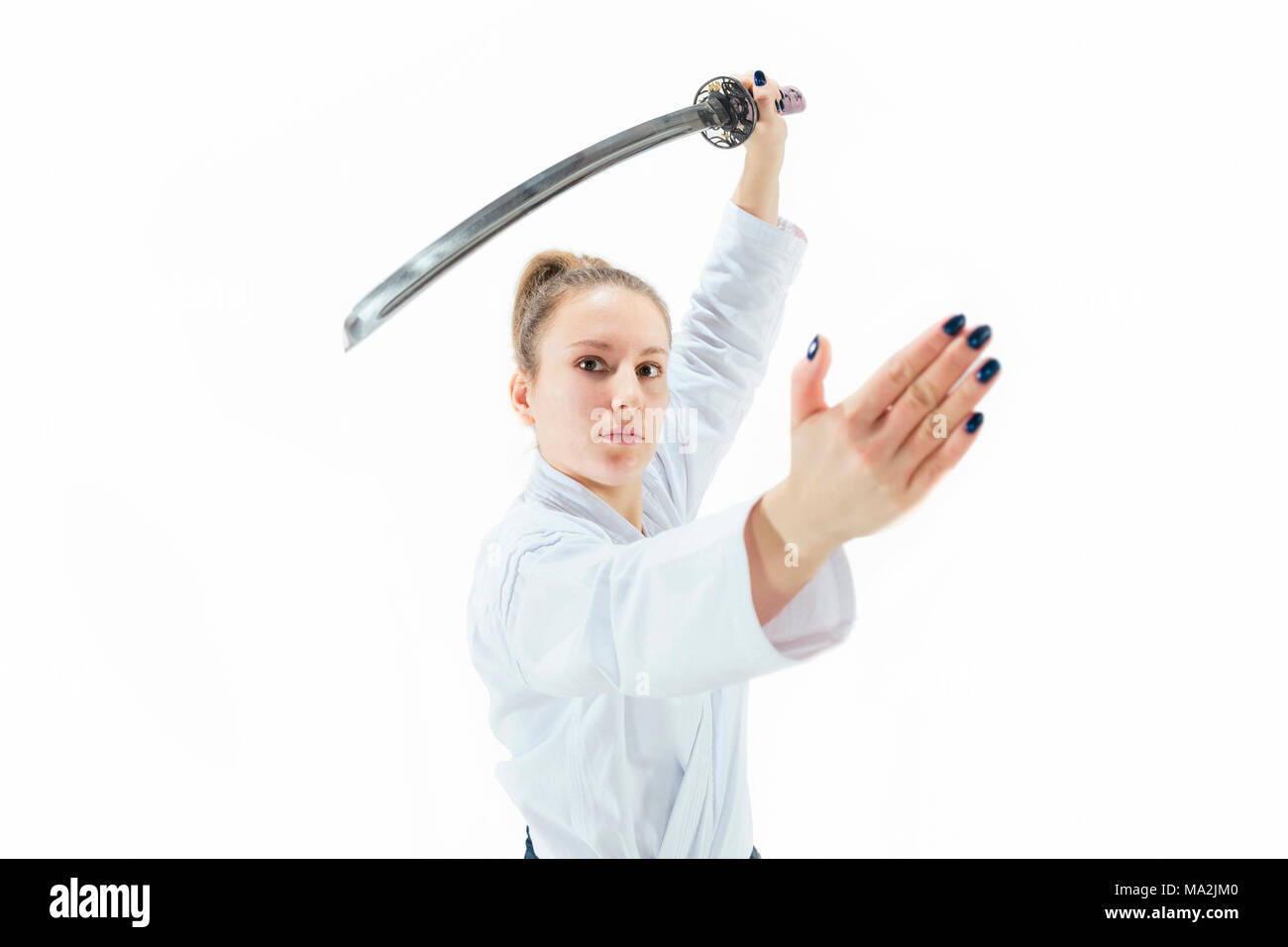 Maître d'Aikido la posture de défense des pratiques. Style de vie sain et de sport concept. Femme en kimono blanc sur fond blanc. Banque D'Images