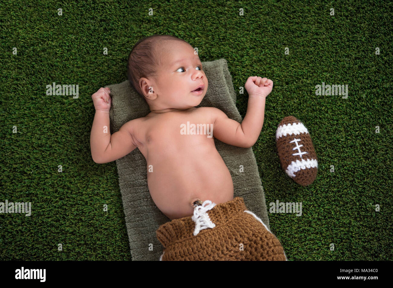 Un Vieux De Deux Semaines Alerte Du Nouveau Ne Baby Boy Lying On Grass Turf Avec Un Football Americain En Bonneterie Photo Stock Alamy
