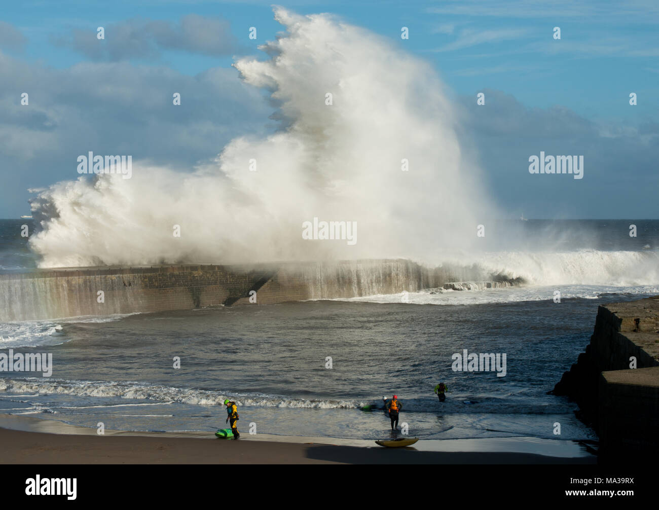 Les amateurs de kayak contemplent d'énormes vagues d'écrasement au-dessus de la jetée de Seaham dans le comté de Durham Banque D'Images