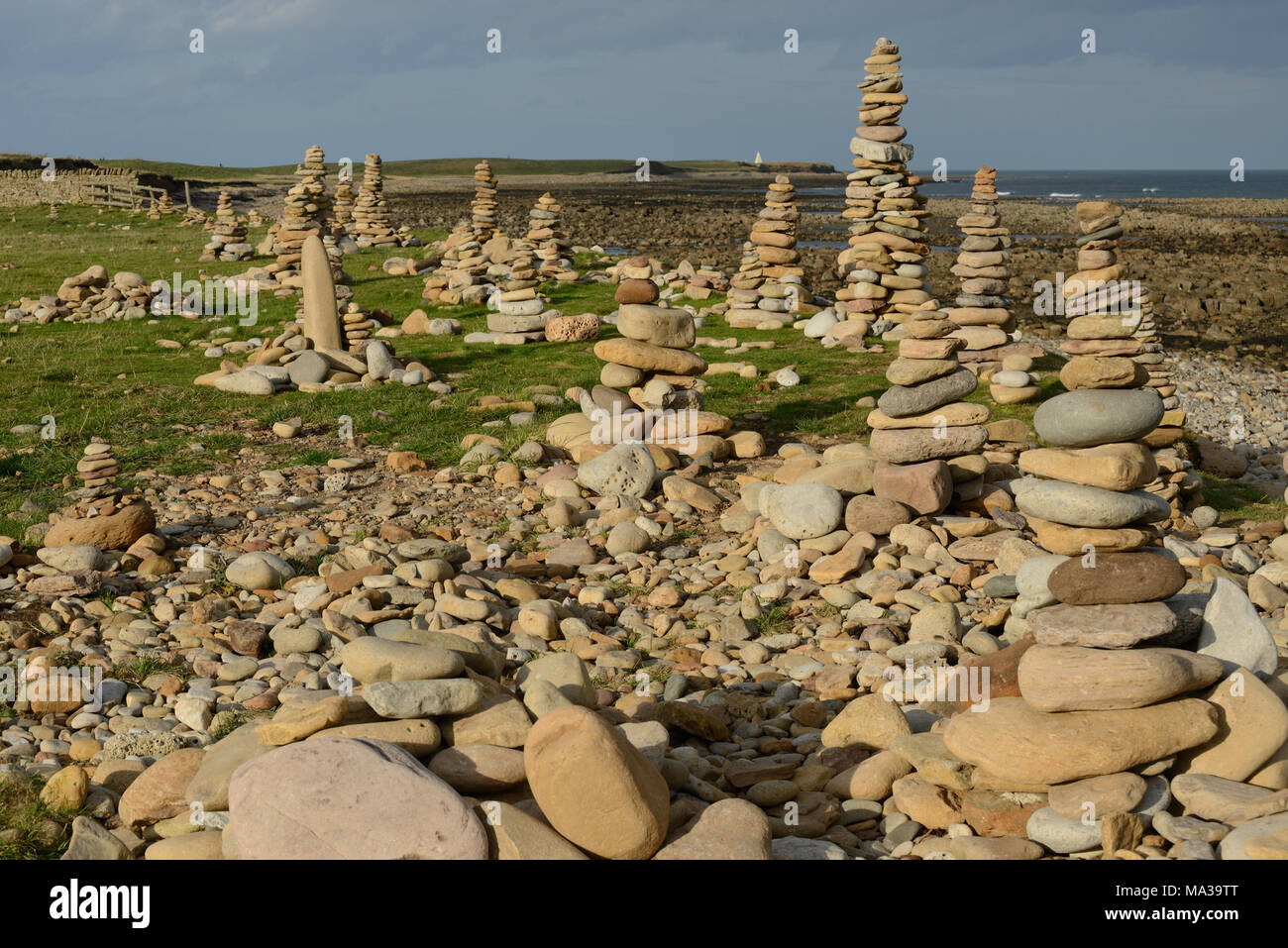 Monument commémoratif en pierre de cairns menant à l'image et construit par des visiteurs sur Lindisfarne également connu sous le nom de Holy Island dans Northumberland Banque D'Images