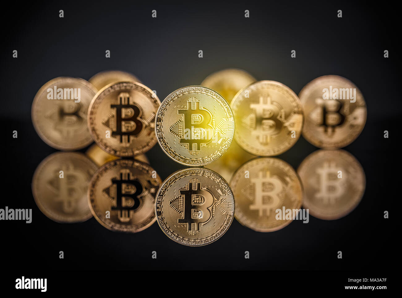 Or de nombreux bitcoins restant sur la surface réfléchissante avec une seule mise au point nette bitcoin Banque D'Images