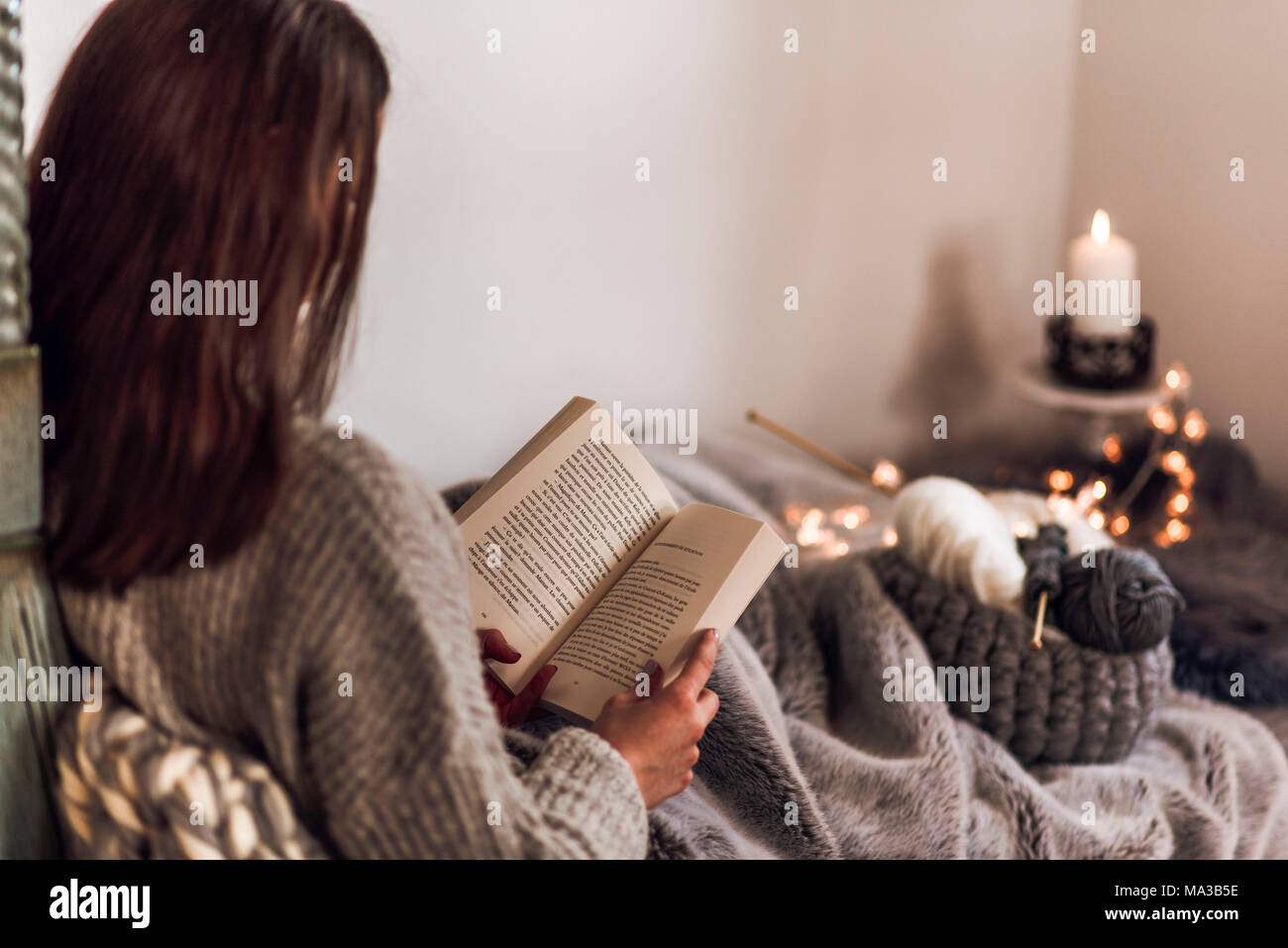 Jeune femme lisant un livre,ambiance chaleureuse Banque D'Images