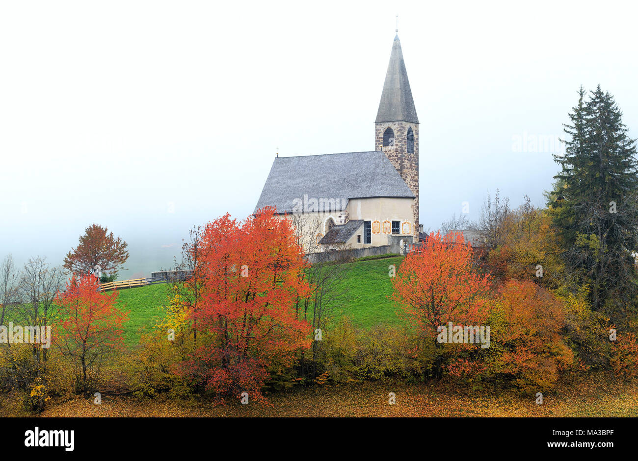 Église de Santa Magdalena dans le brouillard d'automne. Funes Valley, South Tyrol, Dolomites, Italie Banque D'Images