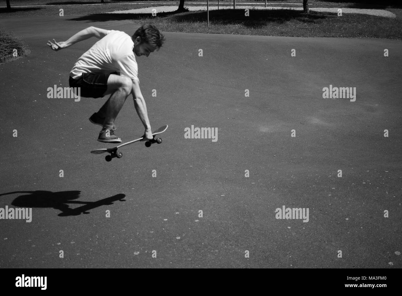 Jeune homme avec son saut skateboard Banque D'Images