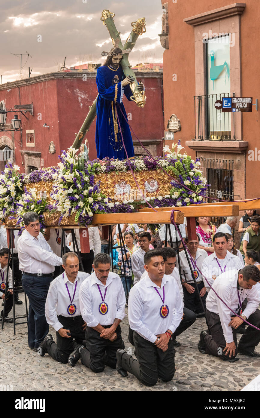 Les fervents catholiques à genoux dans la prière pendant le Las Cruzes del Señor Golpe procession à travers les rues au coucher du soleil dans le cadre de la Semaine Sainte le 28 mars 2018 à San Miguel de Allende, Mexique. L'événement est la récréation de la passion de Jésus Christ sur le chemin de calvaire pour la crucifixion. Banque D'Images