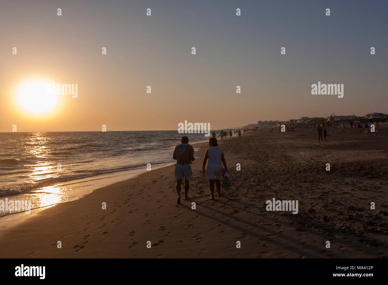 Les gens qui marchent pendant le coucher du soleil à la plage de Matalascañas, Almonte, Province de Huelva, Andalousie, espagne. Banque D'Images