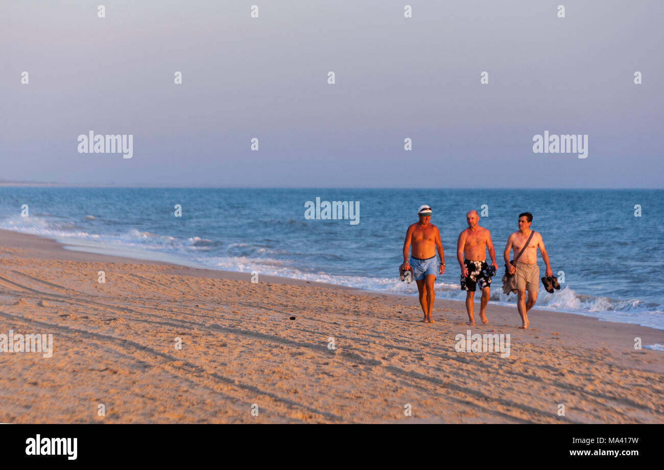 Trois hommes marcher pendant le coucher du soleil à la plage de Matalascañas, Almonte, Province de Huelva, Andalousie, espagne. Banque D'Images
