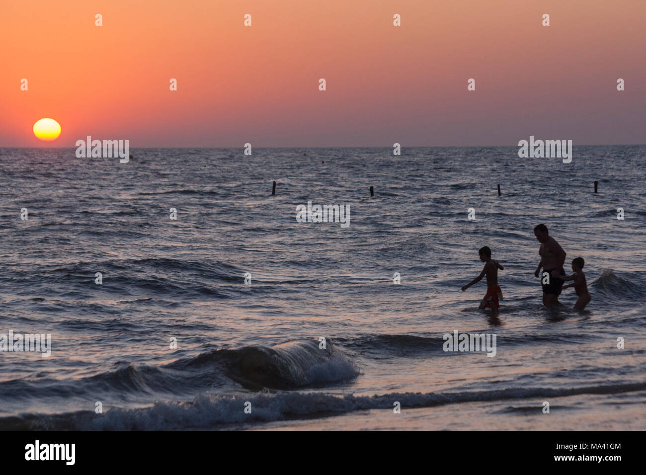 Prendre un bain de famille pendant le coucher du soleil sur la plage de Matalascañas, Almonte, Province de Huelva, Andalousie, espagne. Banque D'Images