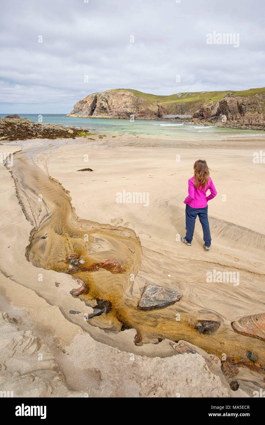 Femme regardant Dailbeag beach, à l'île de Lewis, dans l'ouest de l'Ecosse, Royaume-Uni Banque D'Images