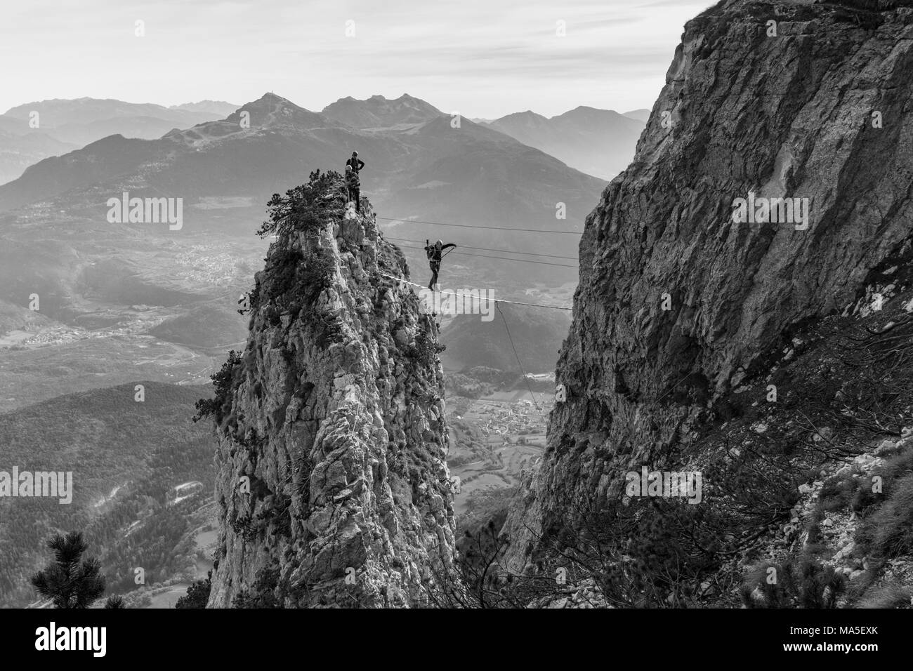 Un randonneur sur un pont tibétain à via ferrata delle Aquile. Paganella, Trento, Trentino, en Italie Banque D'Images