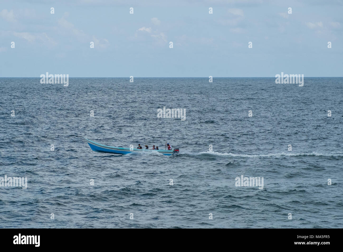 Petit bateau en bois sur les océans - les gens sur le bateau Banque D'Images