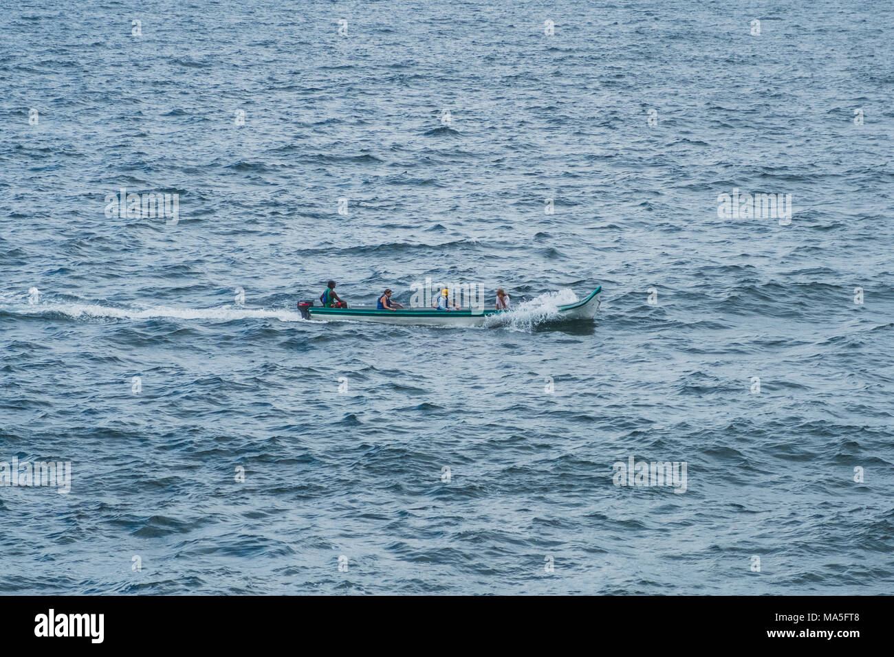 Petit bateau en bois sur les océans - les gens sur le bateau Banque D'Images