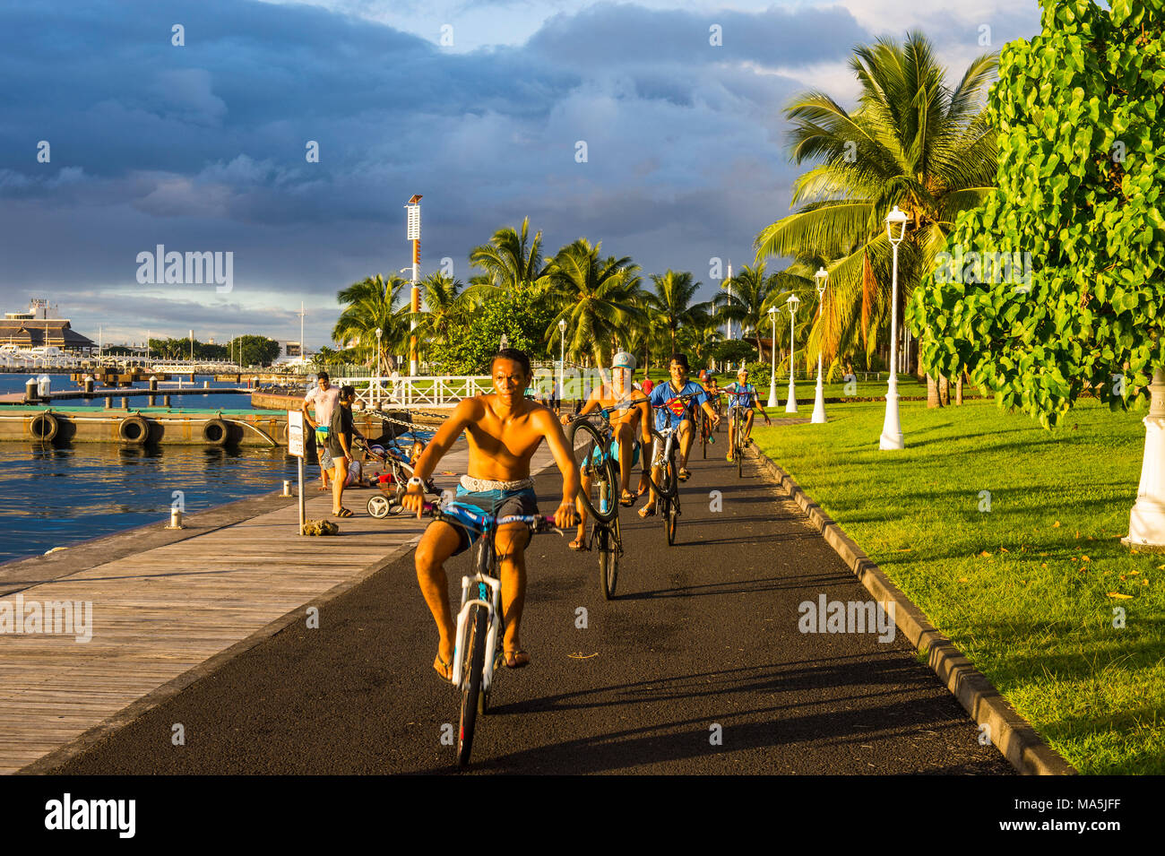 Les garçons locaux sur leur bicyclette, front de mer de Papeete, Tahiti, Polynésie Française Banque D'Images