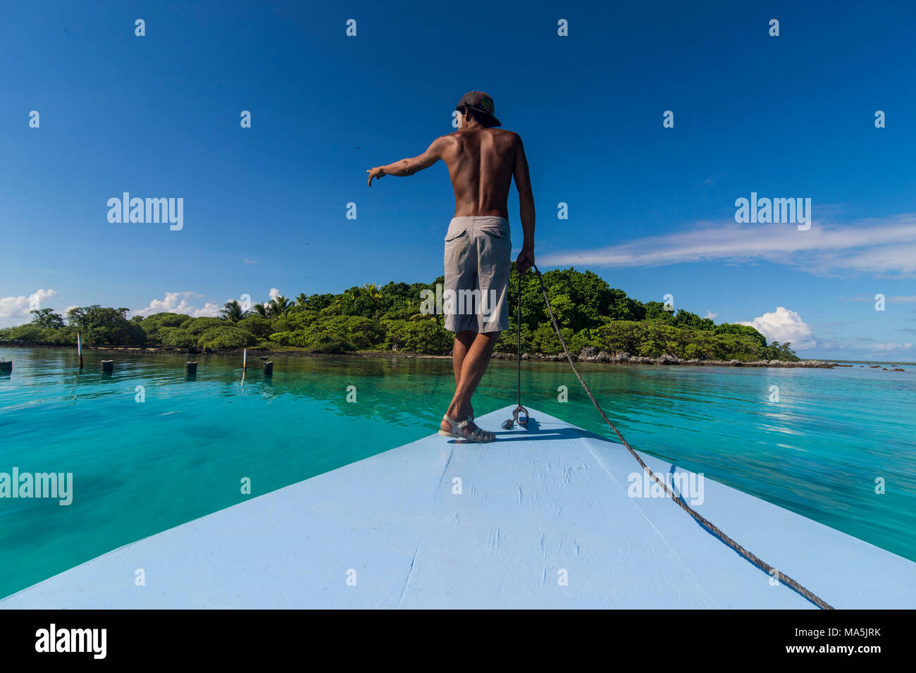 Homme pointant sur un rocher, l'île de Tikehau, Tuamotu, Polynésie Française Banque D'Images