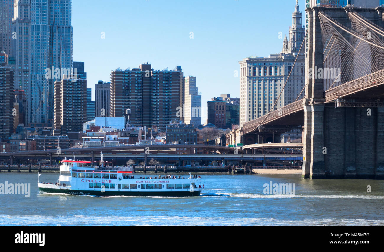 Un bateau d'excursion de la Circle Line sur l'East River à New York en passant le pont de Brooklyn Banque D'Images