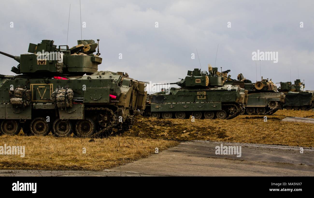 Une ligne de véhicules de combat Bradley M2 et un M1 Abrams tank, du 5e Escadron, 4e régiment de cavalerie blindée, 2e Brigade Combat Team, 1re Division d'infanterie, de numérisation la zone d'entraînement pour les cibles au cours d'un exercice de tir réel interarmes (CALFEX) à Grafenwoehr Domaine de formation, l'Allemagne, Mai 28, 2018. (U.S. Photo de l'armée par la CPS. Hubert D. Delany III / 22e Détachement des affaires publiques mobiles) Banque D'Images