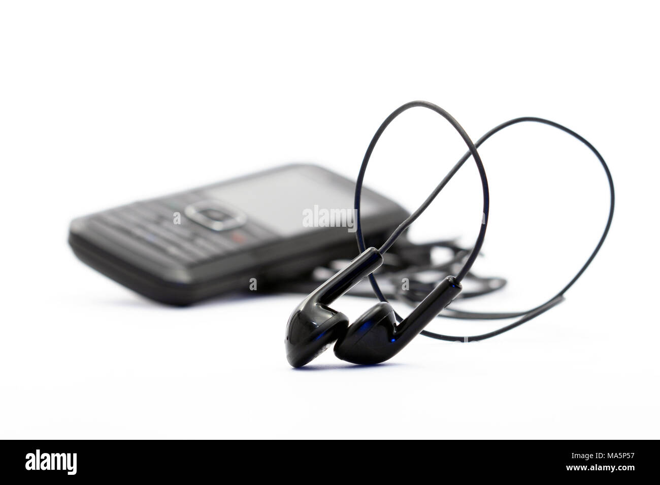 Petits écouteurs sur fond blanc avec téléphone mobile moderne Banque D'Images