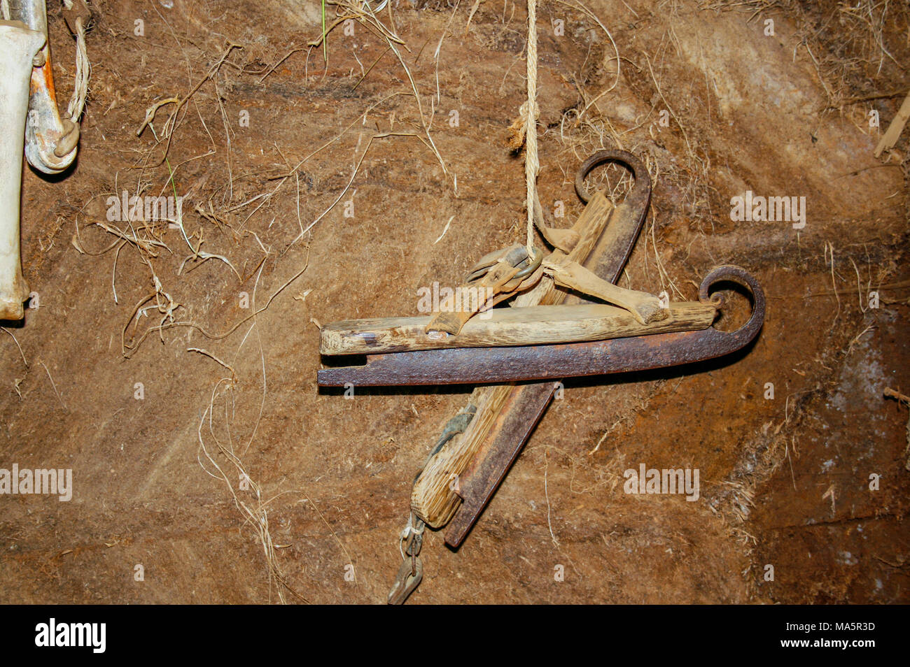 Très vieux patins à glace accroché sur une corde contre un mur d'argile de l'ancienne maison de gazon, une partie de l'os skatses sur la gauche Banque D'Images