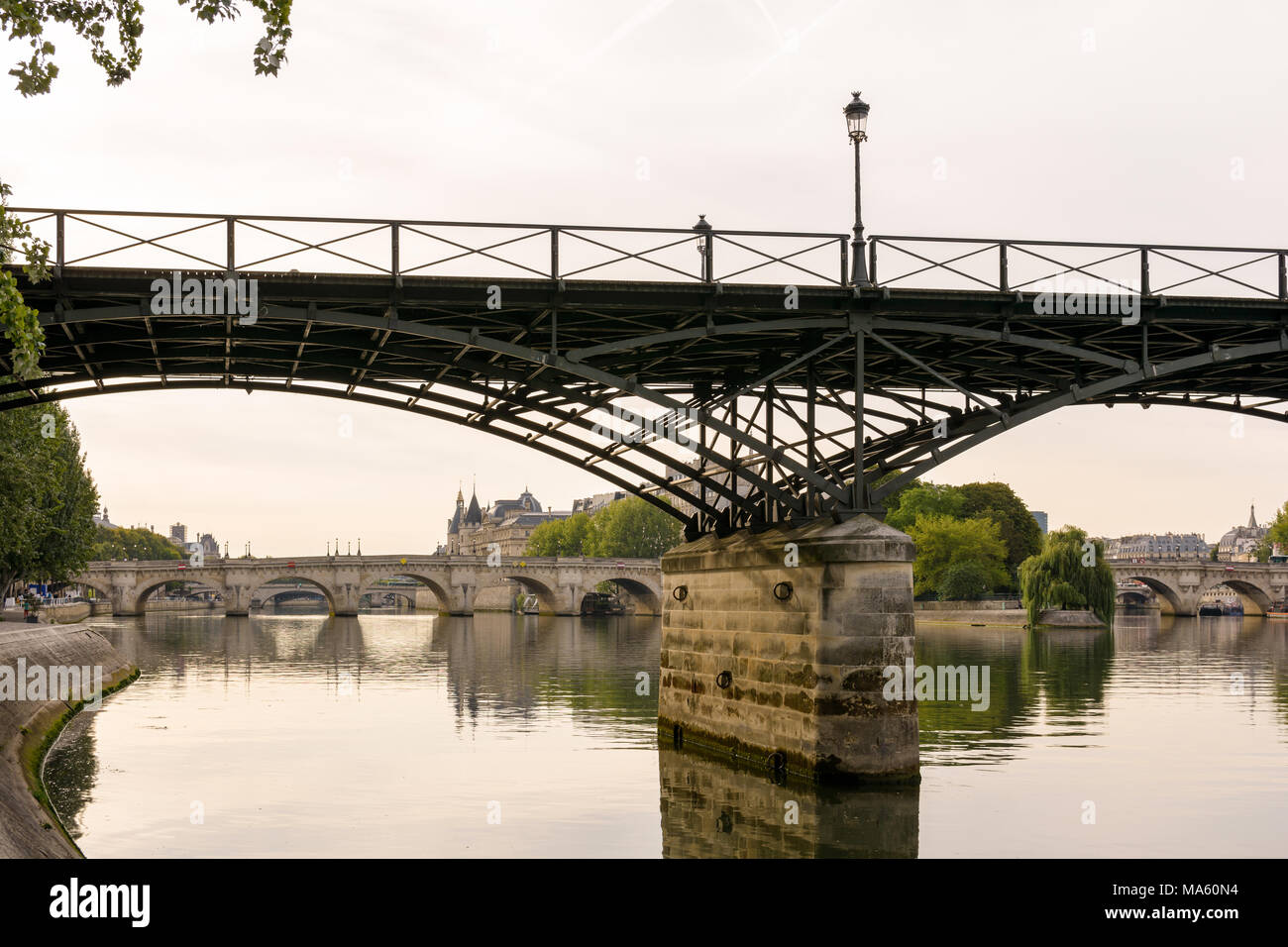 Vue romantique sur le Pont des Arts qui traversent la Seine au centre de Paris, par un matin calme et paisible, avec le Pont Neuf et l'Ile de la C Banque D'Images